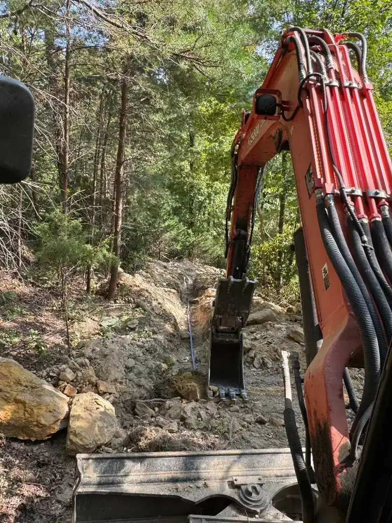 Excavator trenching and moving soil on a Baldwin County residential jobsite for excavation, grading, and site prep — Excavation Elite